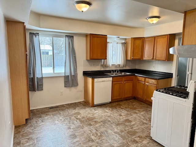 kitchen featuring sink, white appliances, tasteful backsplash, and a wealth of natural light