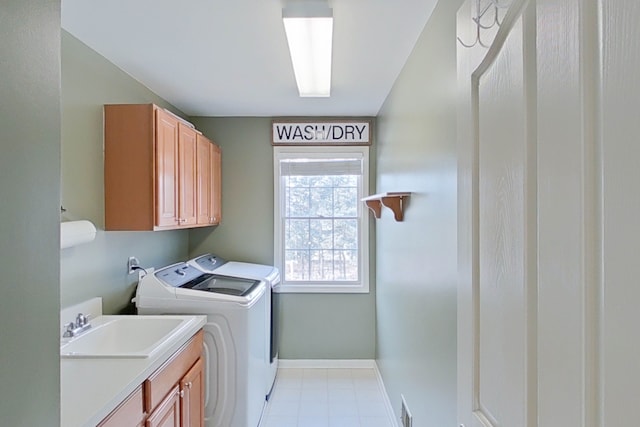 washroom with cabinets, sink, and washing machine and clothes dryer