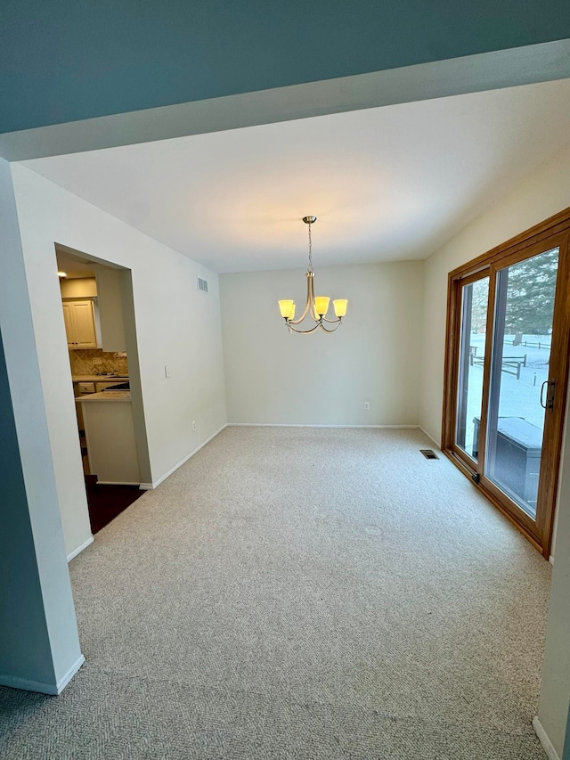 unfurnished room with carpet and a notable chandelier