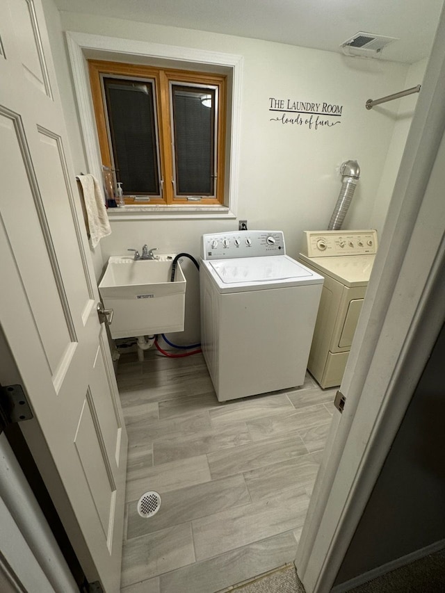 laundry room with separate washer and dryer and sink