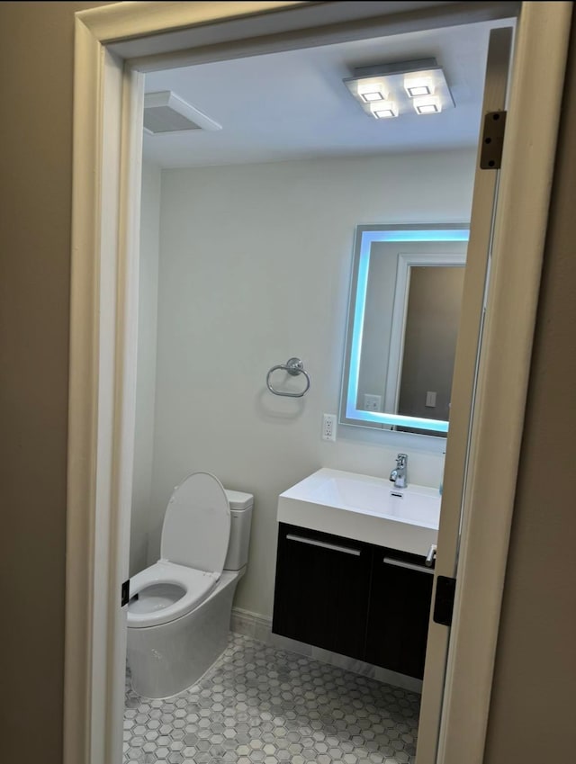 bathroom with toilet, tile patterned floors, and vanity