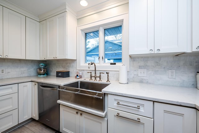 kitchen with light stone countertops, stainless steel dishwasher, backsplash, and white cabinetry