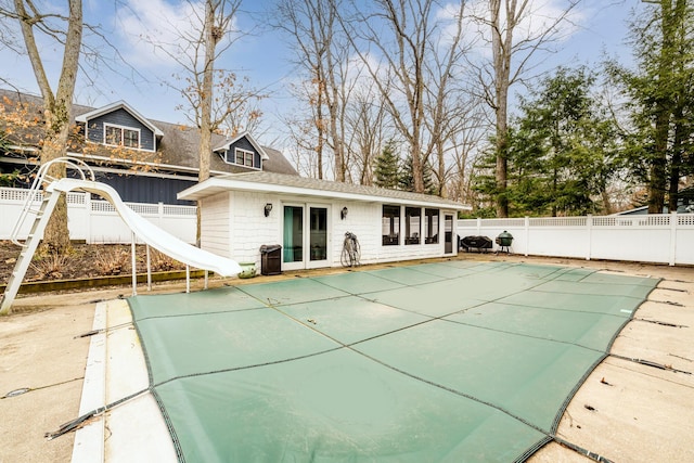 view of swimming pool featuring a water slide and french doors