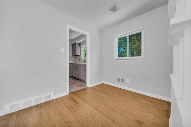 unfurnished room with sink and light wood-type flooring