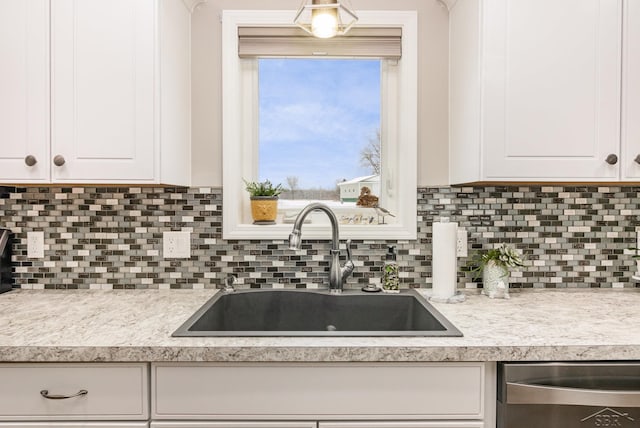 kitchen with sink, white cabinets, dishwasher, and tasteful backsplash