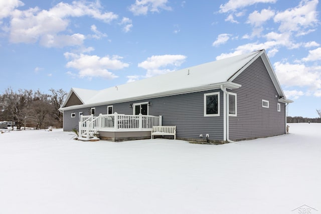 snow covered property featuring a wooden deck