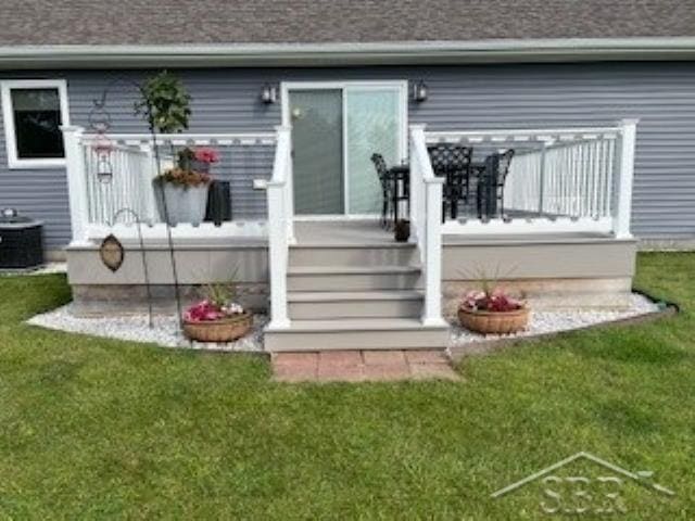 back of property with central AC unit and a lawn