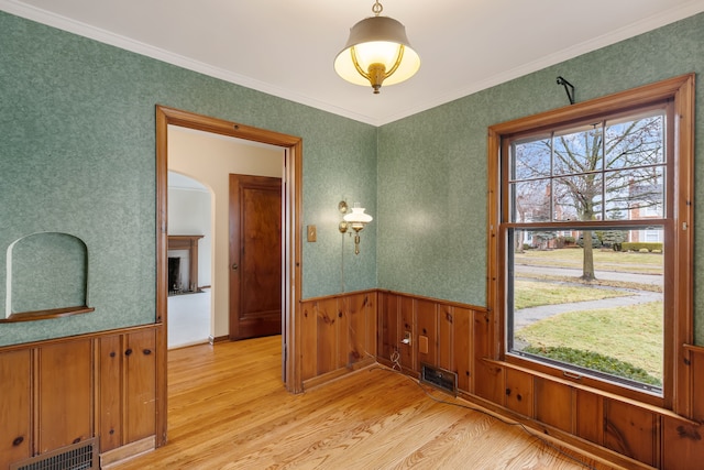 interior space with a wainscoted wall, visible vents, and a wealth of natural light