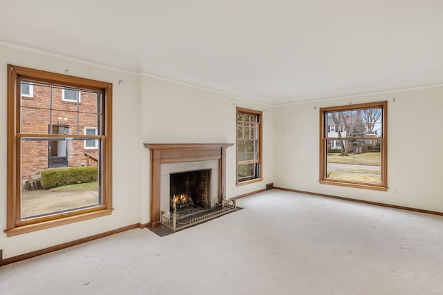 unfurnished living room with a fireplace with flush hearth, carpet flooring, crown molding, and baseboards