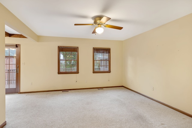 unfurnished room with a wealth of natural light, carpet flooring, and baseboards