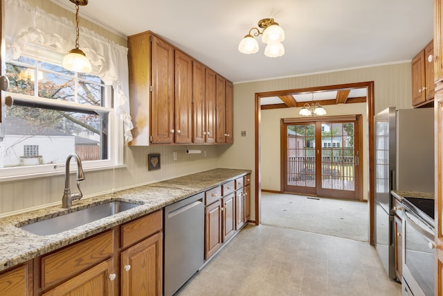 kitchen with a chandelier, appliances with stainless steel finishes, brown cabinetry, and a sink