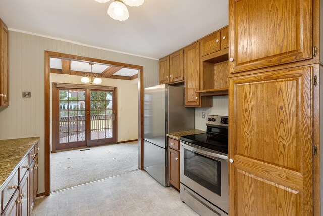 kitchen with light stone counters, a notable chandelier, stainless steel appliances, brown cabinetry, and light carpet