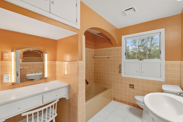 full bath with visible vents, a sink, and tile walls