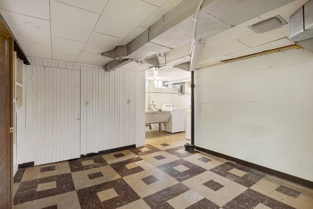 basement featuring washer / clothes dryer, a sink, and tile patterned floors