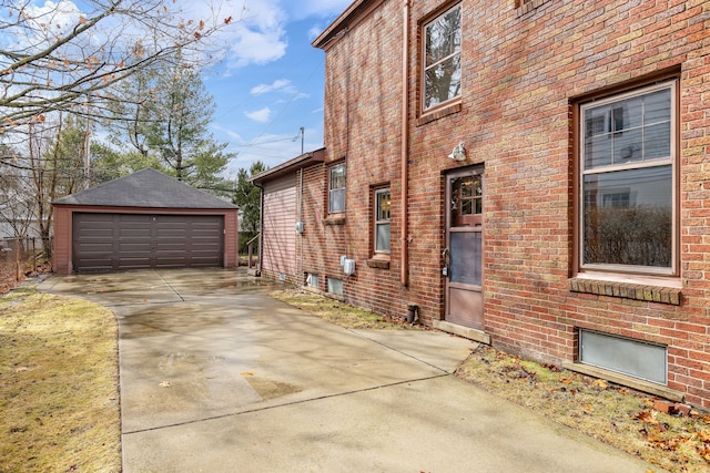 view of side of property featuring an outbuilding, brick siding, and a garage