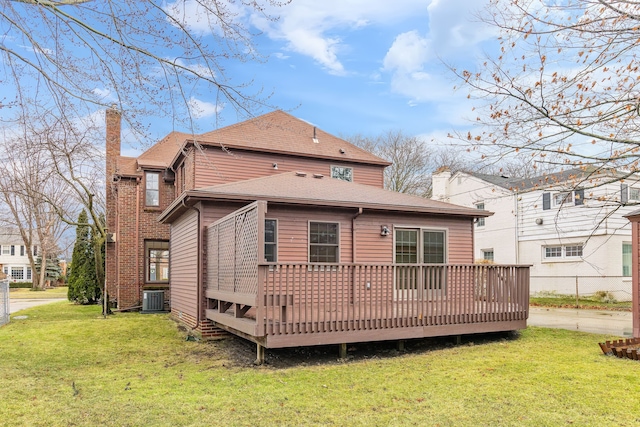 back of property featuring a deck, a lawn, a chimney, and central air condition unit