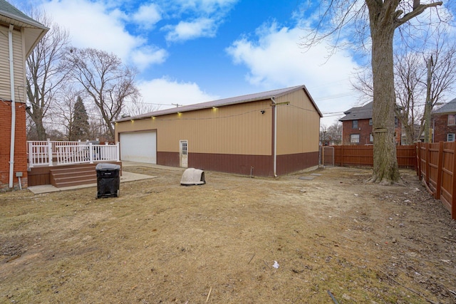 exterior space with a deck, a garage, and an outdoor structure