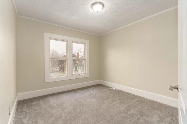 empty room with a textured ceiling, ornamental molding, and carpet