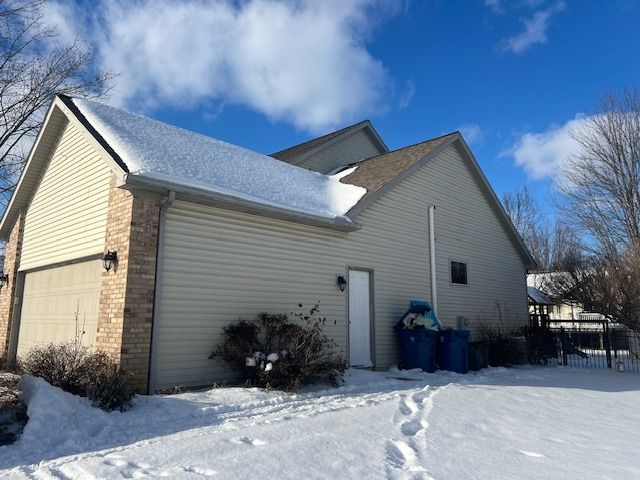 view of snow covered exterior featuring a garage