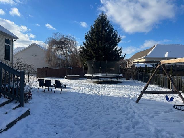 snowy yard featuring a trampoline