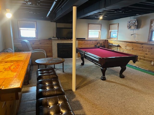 game room featuring pool table, wooden walls, a healthy amount of sunlight, and carpet