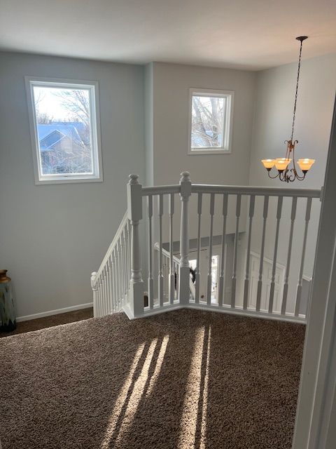 stairs with an inviting chandelier