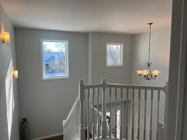 stairway with an inviting chandelier and a healthy amount of sunlight