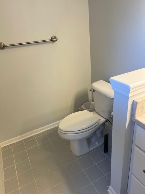 bathroom with toilet, tile patterned floors, and vanity