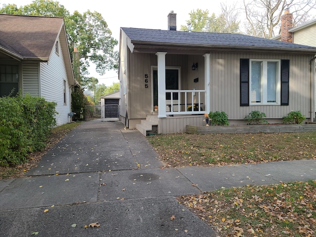 view of front of home with covered porch, a garage, and an outdoor structure