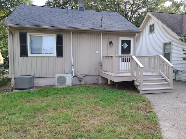 view of front of house featuring ac unit, central AC unit, and a front yard