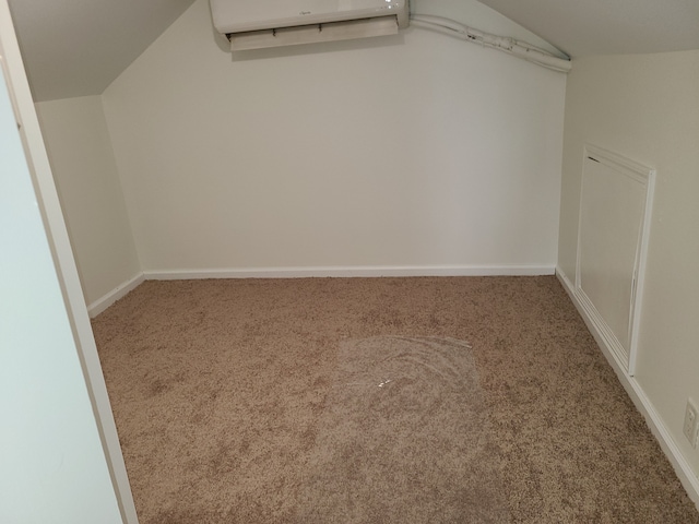 spacious closet with carpet floors, vaulted ceiling, and a wall mounted air conditioner