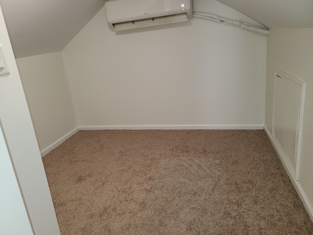 walk in closet with a wall mounted AC, carpet floors, and vaulted ceiling