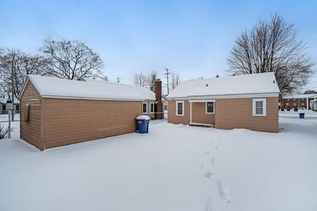 view of snow covered back of property