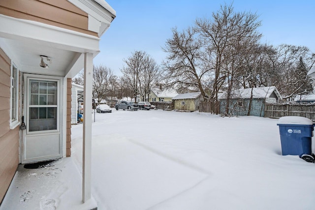 yard layered in snow with a storage unit