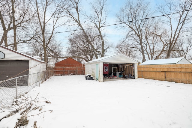 snowy yard with an outdoor structure and a garage