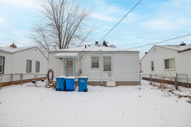 view of snow covered back of property