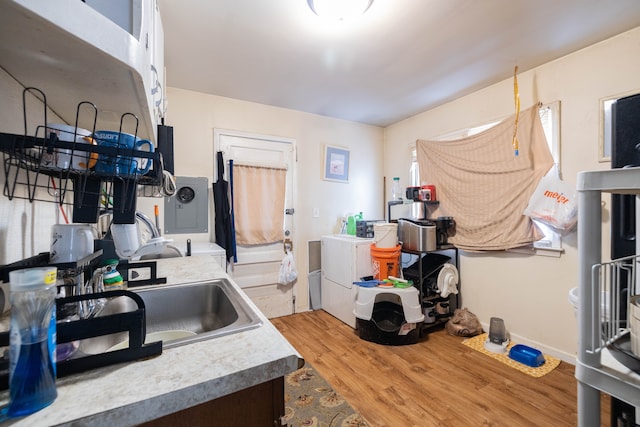 kitchen featuring washer and clothes dryer, sink, and light hardwood / wood-style floors