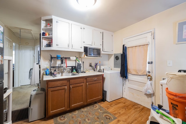 kitchen with sink, white cabinets, light wood-type flooring, and washer / clothes dryer