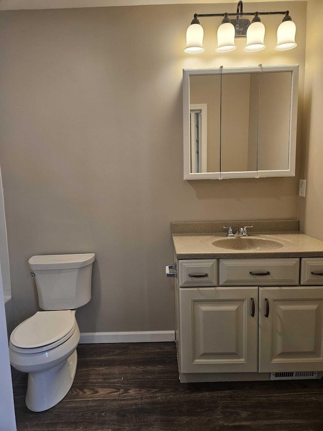 bathroom featuring toilet, wood-type flooring, and vanity