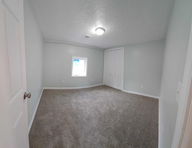 carpeted spare room with a textured ceiling