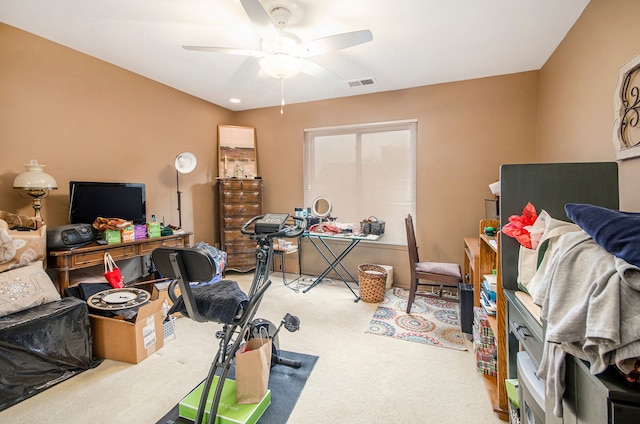 exercise area featuring ceiling fan and light colored carpet