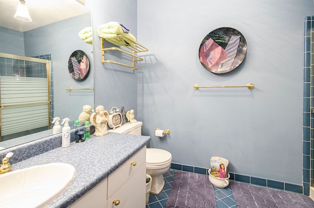 bathroom featuring vanity, toilet, walk in shower, and tile patterned floors