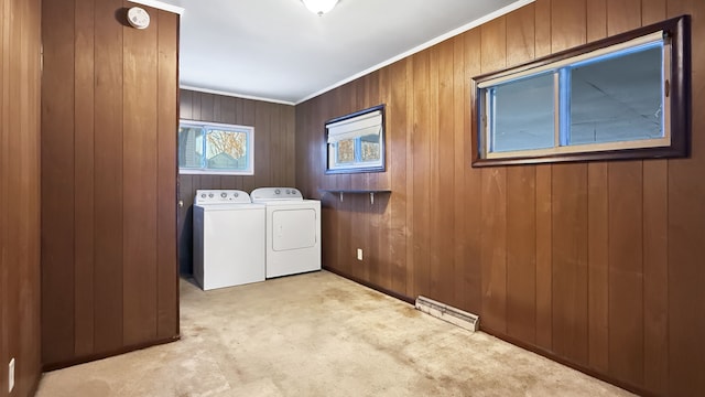 clothes washing area with light colored carpet, wooden walls, ornamental molding, and independent washer and dryer