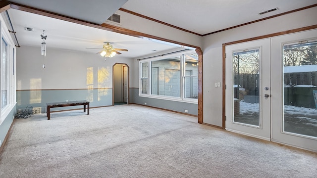 carpeted spare room featuring ornamental molding, ceiling fan, and french doors