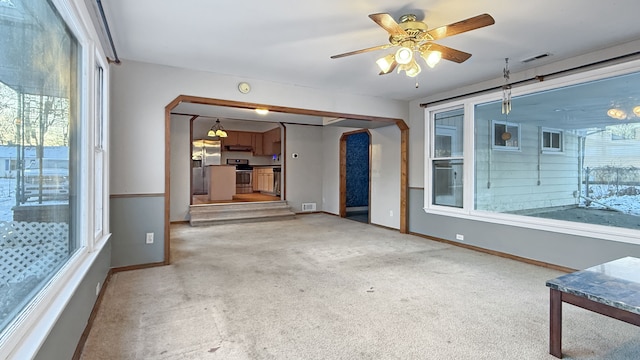 unfurnished living room featuring ceiling fan and carpet flooring