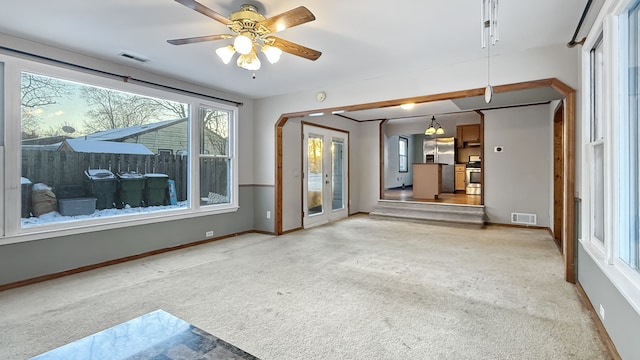 unfurnished living room with light colored carpet and ceiling fan