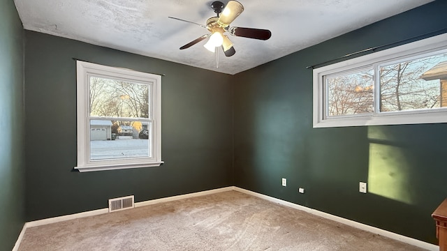 carpeted spare room with ceiling fan and a textured ceiling