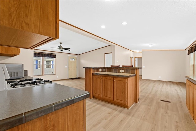 kitchen featuring crown molding and light hardwood / wood-style flooring