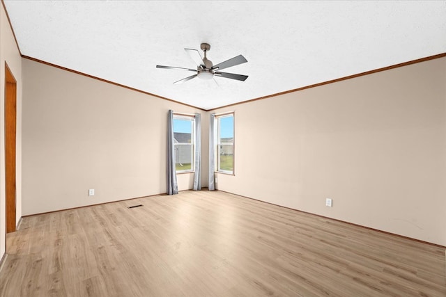 unfurnished room featuring light hardwood / wood-style floors, ceiling fan, ornamental molding, and vaulted ceiling