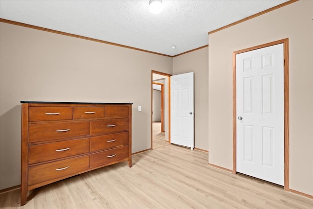 unfurnished bedroom with light hardwood / wood-style floors, ornamental molding, and a textured ceiling